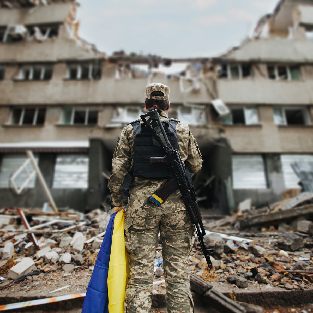Solder 2 edited Ukranian soldier standing in front of destroyed building.